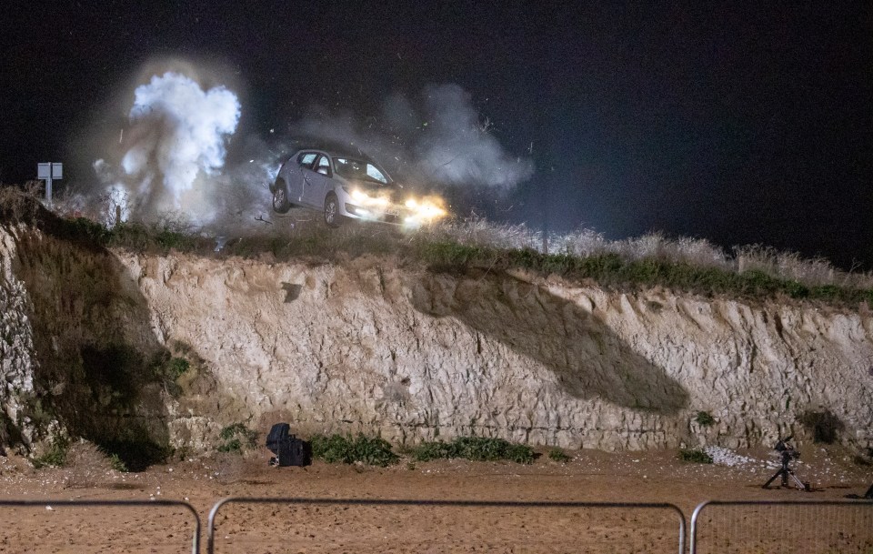 Mick goes over the cliff after a car believed to be carrying his estranged wife Linda and lover Janine Butcher