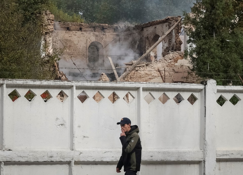 A local resident passes by a building damaged by a Shahed-136 strikes in Bila Tserkva, Kyiv region