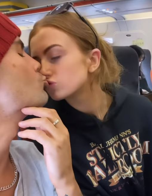Max uploaded a snap of them sharing a kiss on the plane as they jetted off on holiday