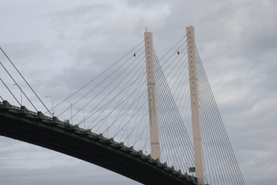 The protesters are suspended hundreds of feet above the Thames