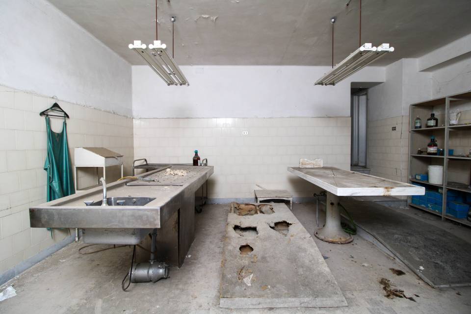 The examination beds rusted into ruin at the abandoned  morgue