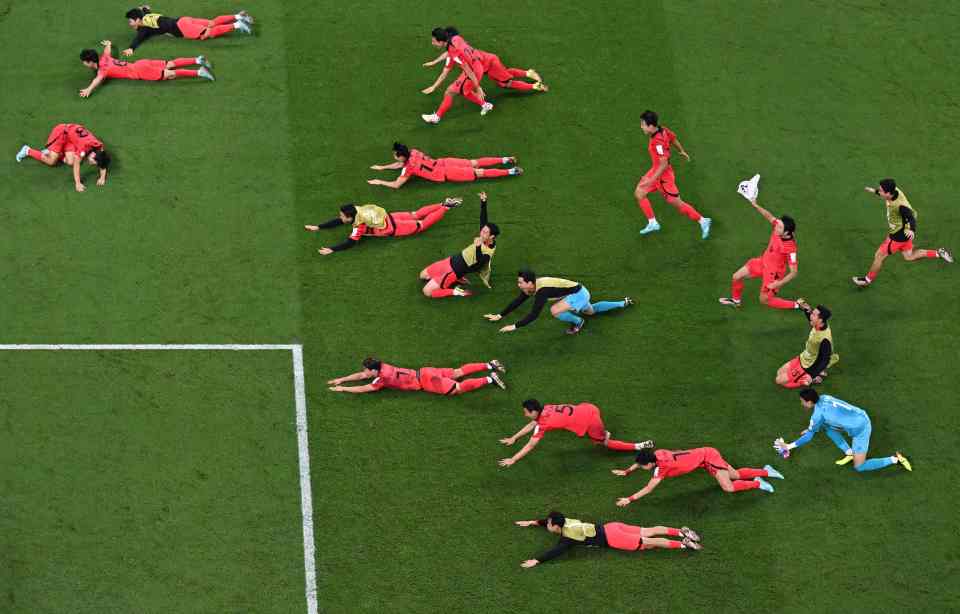 The players dive across the pitch in front of the travelling fans