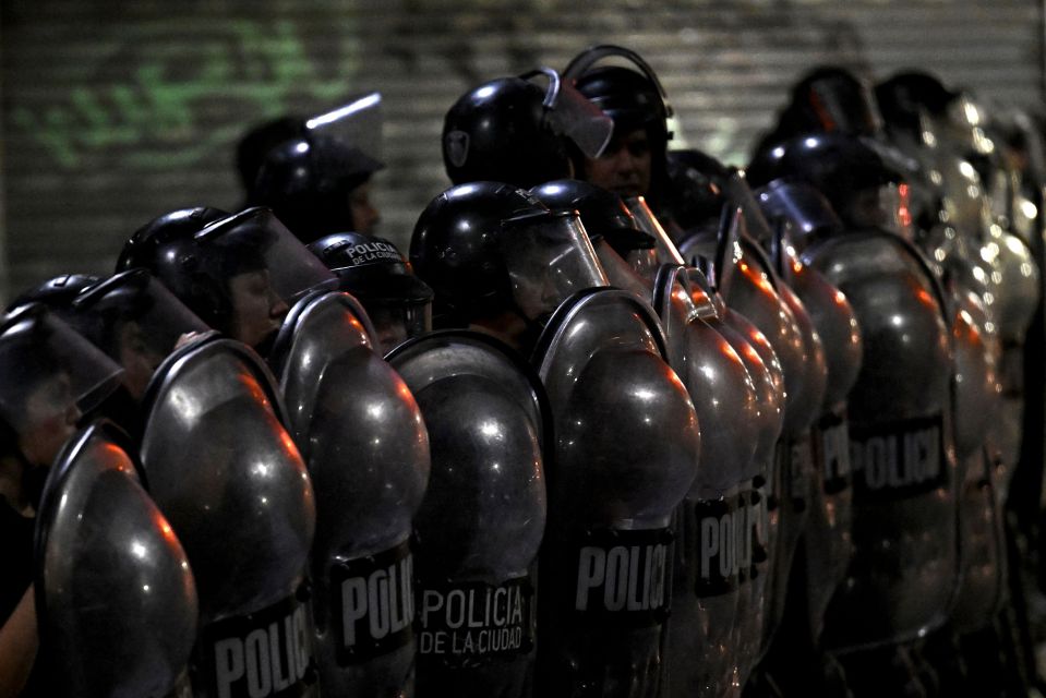 Riot police stand guard during clashes with fans