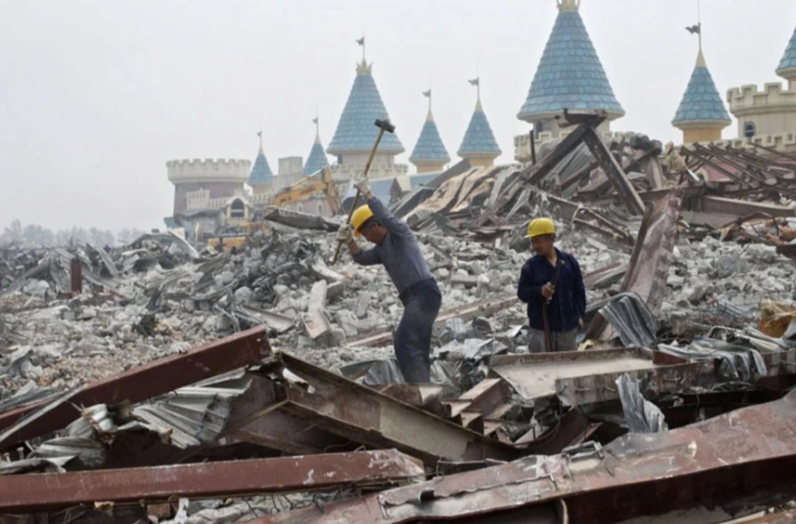 two men are working in a pile of rubble with castles in the background