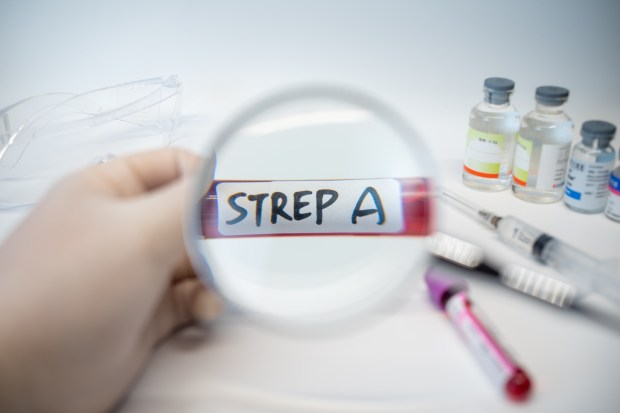 Blood sample tube labeled "Strep A" viewed through a magnifying glass.