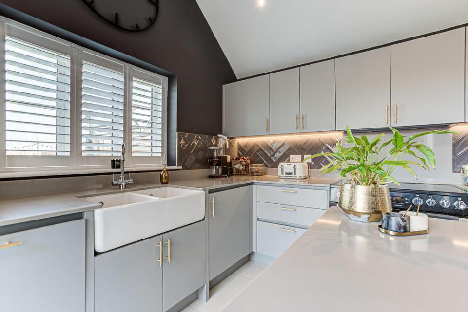 It boasts white cupboards and matching shiny work surfaces