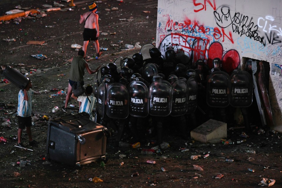 Police form a phalanx during clashes with remaining fans