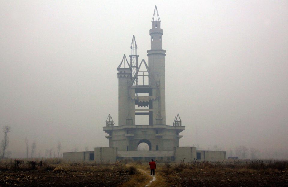a person standing in front of a castle in the fog