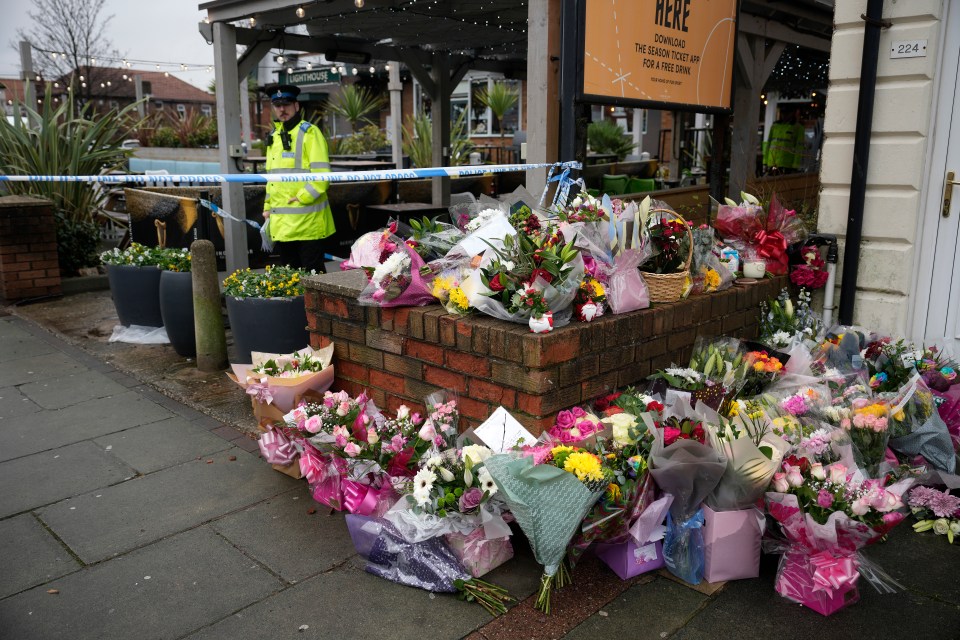 Flowers and police outside the Lighthouse Pub in Wallasey
