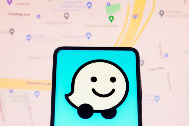 Photo illustration of the Waze logo on a smartphone screen.