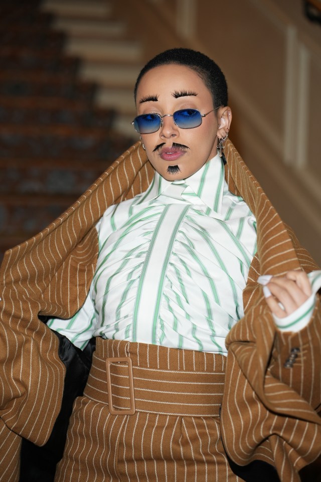 Doja Cat dresses as a bloke with crazy fake eyelashes, goatee and tache at Paris Fashion Week