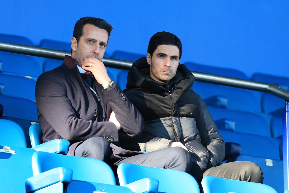 a man in a suit sits next to another man in a black jacket