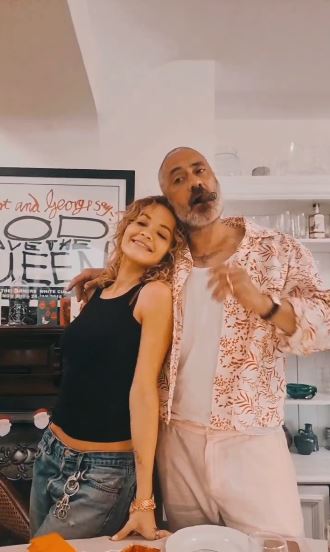 Rita and husband Taika pose in her living room at Christmas