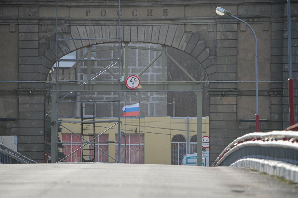 The Russian flag waves in the chill wind as The Sun stood on the narrow bridge to Russia