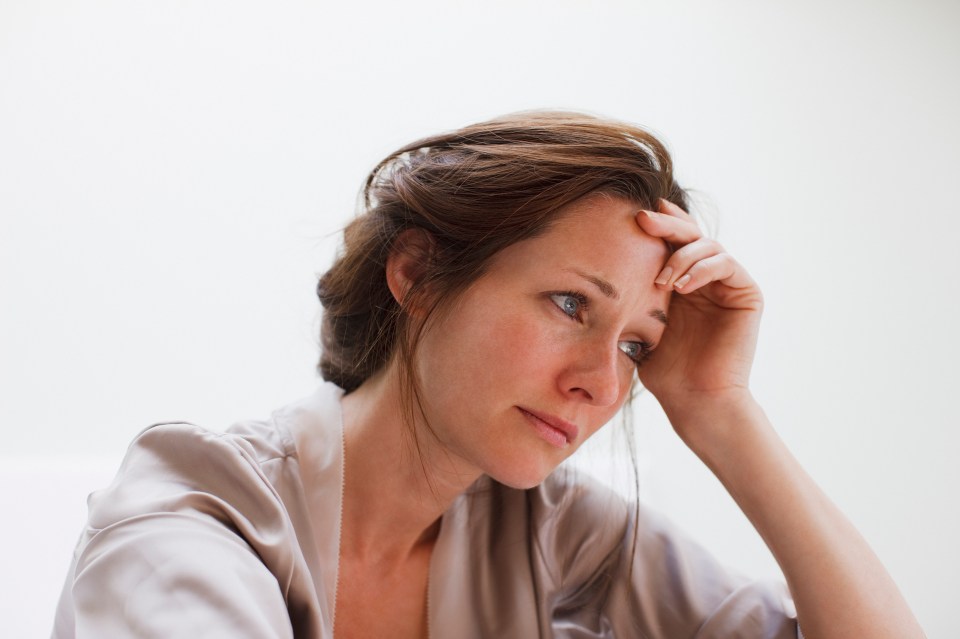 A sad woman holding her head in her hands.