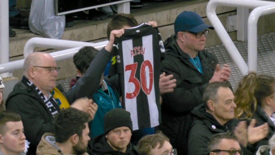 A fan held a shirt with Atsu's name on the back aloft