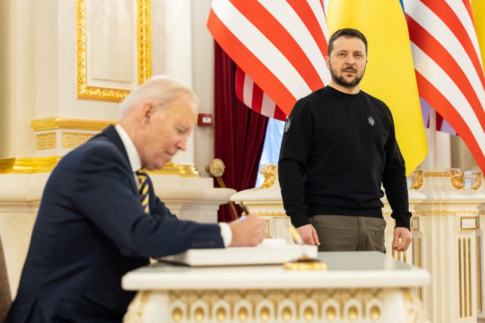 Biden signs a book as he visits Zelensky