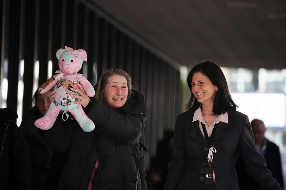 Olivia's mum Cheryl holds a pink teddy aloft in memory of her daughter outside court after Cashman was found guilty of murder