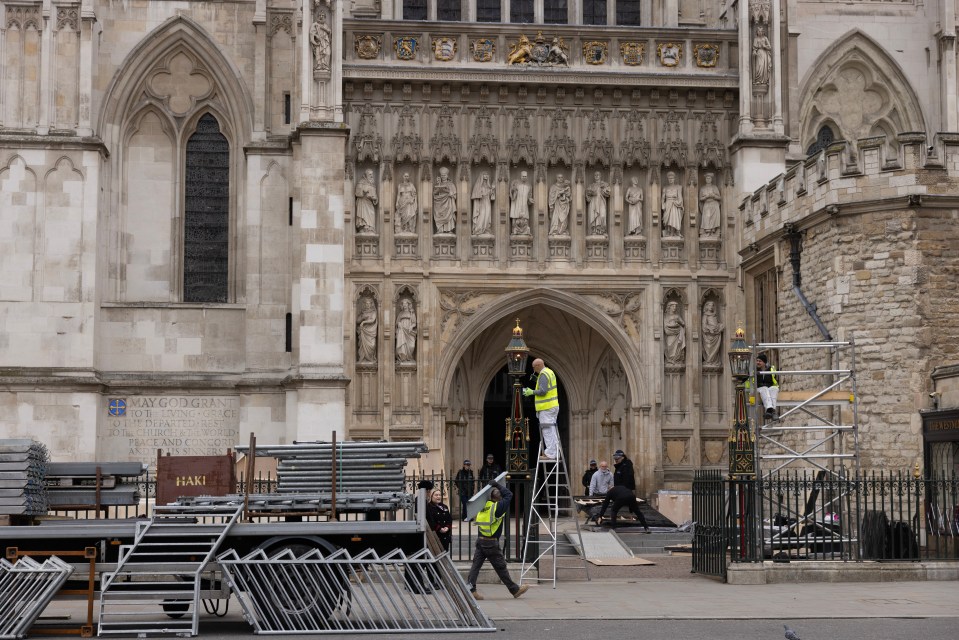 Finishing touches are made to the lamps outside the Great West Door of Westminster Abbey ahead of the coronation next Saturday