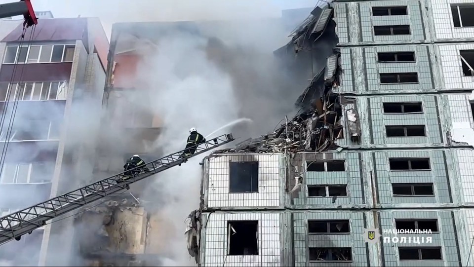 Rescuers work at the site of a heavily damaged residential building in the town of Uman