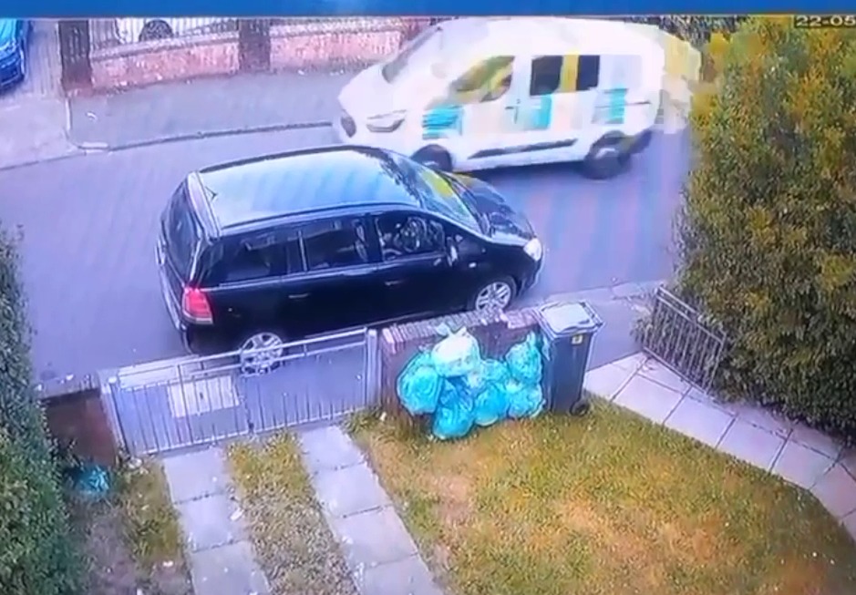 A police van comes into shot immediately after them