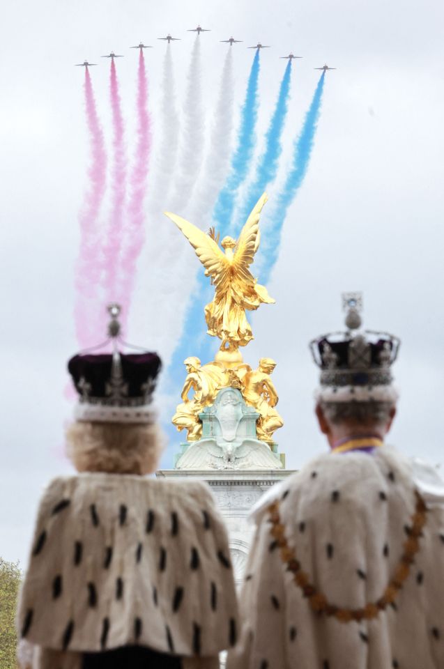 The couple stood side by side as the Red Arrows flew above them