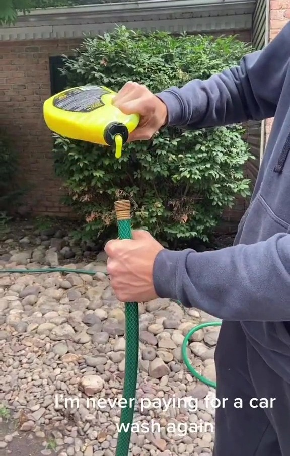 The man is seen pouring cleaning fluid directly into a garden hose