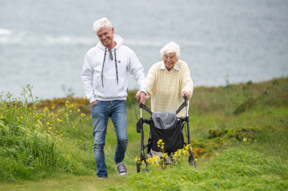 EXCLUSIVE: Phillip Schofield shares emotional walk with mum Pat today in the West Country as his brother Timothy is jailed for 12 years over sexual acts with a minor. ..The pair hugged and also laughed as they strolled in the sunshine, stopping for an embrace on a bench before sharing happy moments along the coastal path. Pat, 85, will be 91 before Timothy is eligible for parole.....Pictured: Pat Schofield,Phillip Schofield..Ref: SPL6856491 190523 EXCLUSIVE..Picture by: Spartacus / SplashNews.com....Splash News and Pictures..USA: 310-525-5808.UK: 020 8126 1009..eamteam@shutterstock.com....World Rights..