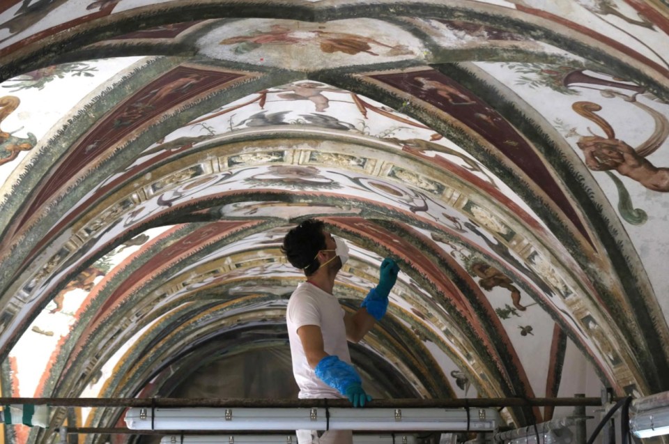 A restorer works on a fresco in the Galerie d’Hercule