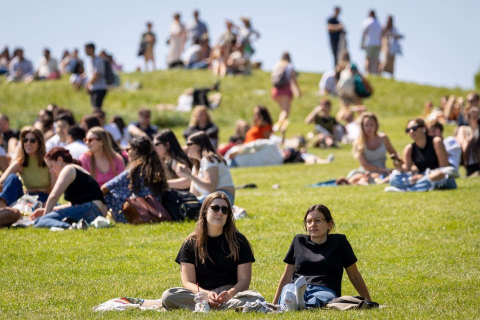 People relaxed in Primrose Hill, North London, where temperatures hit 21C