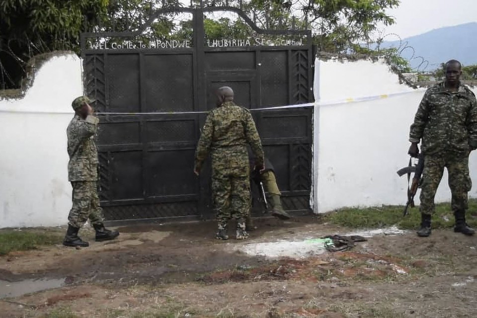 Uganda security forces guard the school gates following the massacre