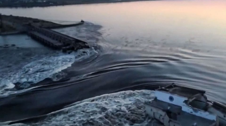 Aerial views showing a wall of water escaping the destroyed dam