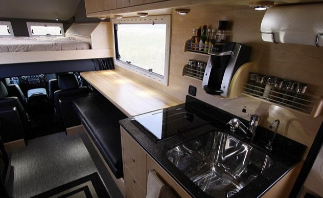 The kitchen also includes an expresso machine, a sink, a stove and a spice rack