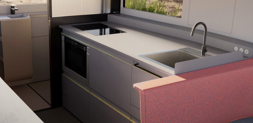 The indoor kitchen boasts a small refrigerator, stove, oven and large countertops