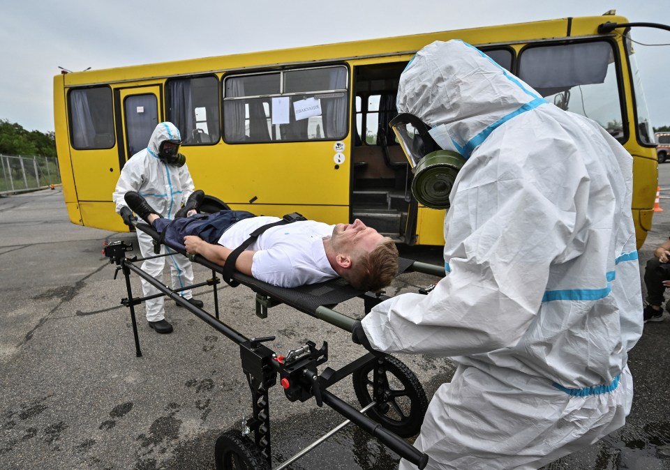 Rescuers and police officers carry a man on a stretcher in anti-radiation drills in Ukraine