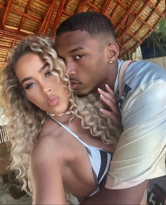 a man and woman are posing for a picture and the woman is wearing a bikini top