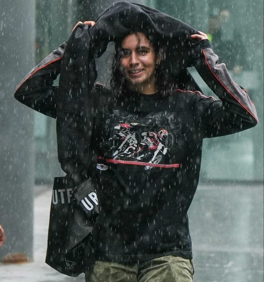 Heavy rain is predicted in most areas, like this woman struggled with in Manchester on July 10