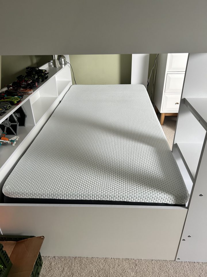 Mattress on a white bunk bed.