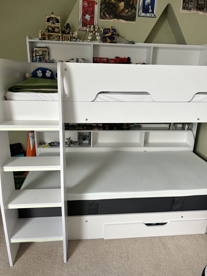 White bunk bed with built-in shelving and storage drawer.