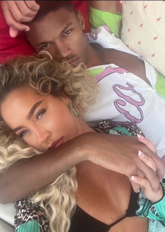a man and a woman laying next to each other with the man wearing a shirt that says ' gucci ' on it