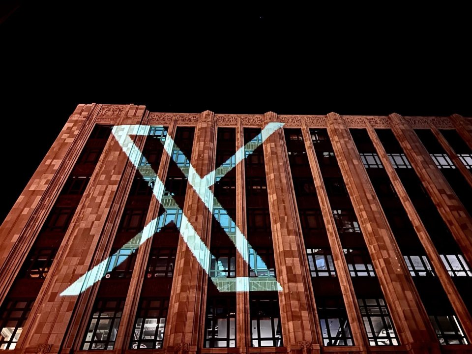 Twitter blasting its new logo on the side of its San Francisco HQ