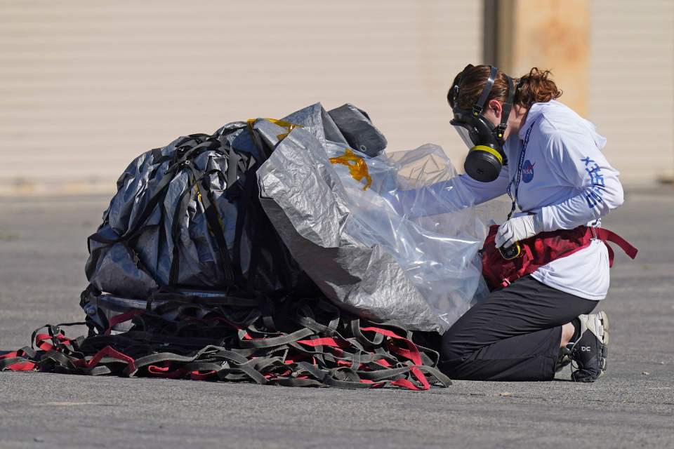 A recovery team member examines the capsule before being taken to a temporary clean room at Dugway Proving Ground in Utah