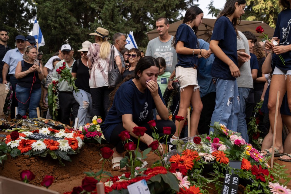 Mourners weep at the funeral of a mum and son killed in Hamas's ambush on Be’eri
