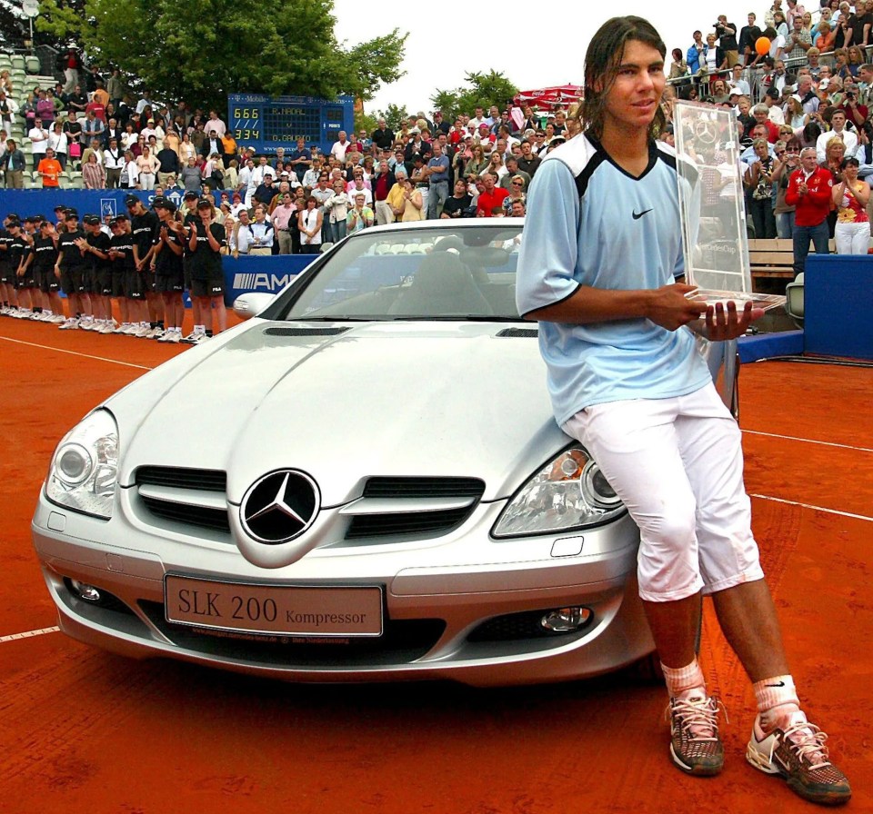 a man stands in front of a silver mercedes slk 200 kompressor