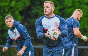 England rugby league player holding a rugby ball during training.