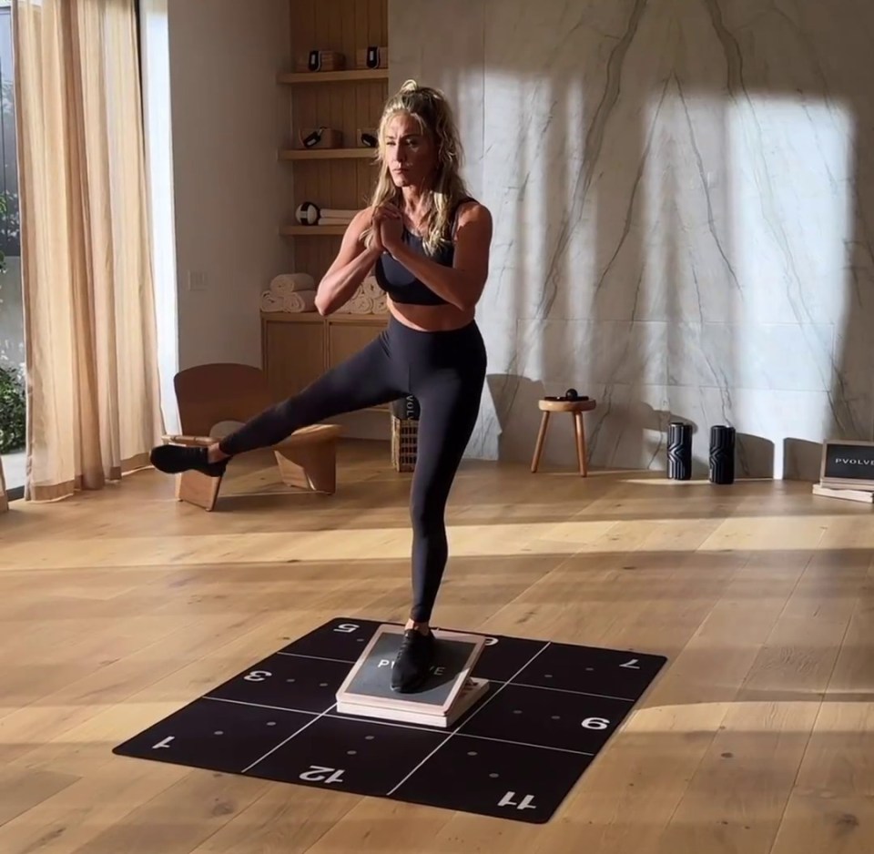 a woman is doing squats on a mat with the number 11 on it