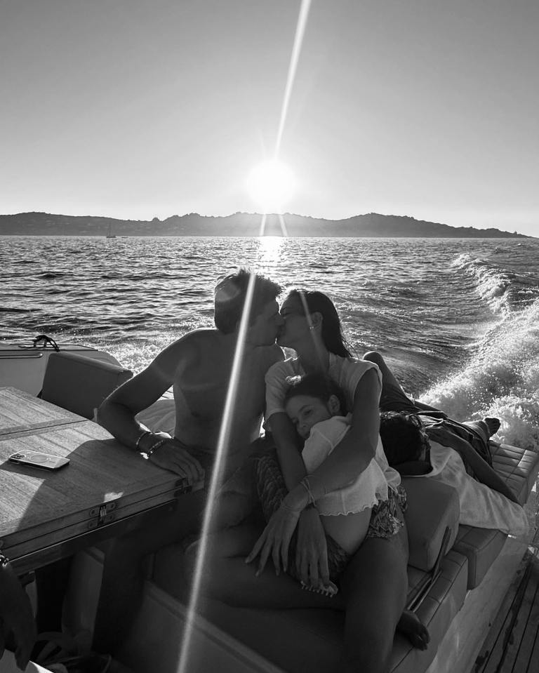 Max shares a kiss with Kelly during a boat ride while her daughter looks into the camera
