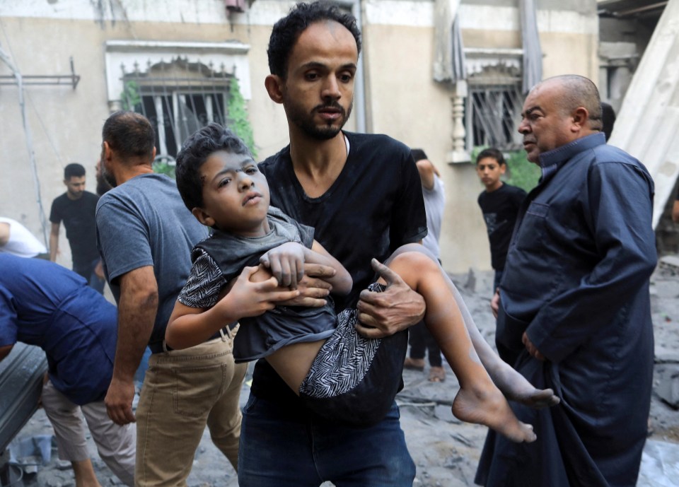 A man carries a wounded child in the aftermath of an Israeli strike in the southern Gaza Strip