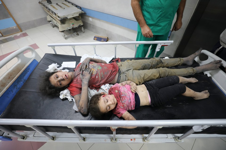Two young girls share a bed as they wait to be seen