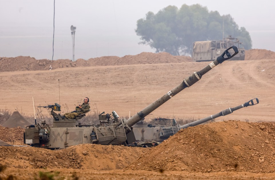 Israeli soldiers man howitzers near Gaza